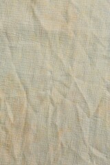 Vertical shot of a wrinkled, cream-colored piece of cloth - weathered white cloth texture