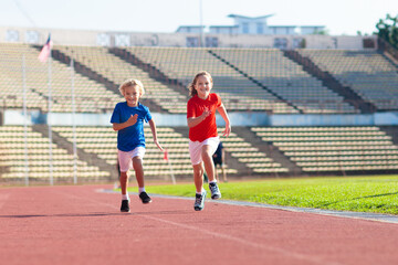 Obraz premium Child running in stadium. Kids run. Healthy sport.