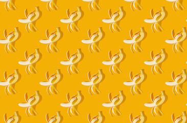Pattern of peeled bananas on orange pastel background