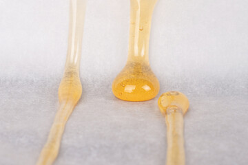 dripping drops of yellow cannabis wax with a high content of thc on paper.