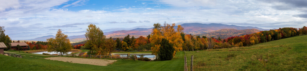 Panorama of a farm overlooking over the moutains in the fall with all the colors