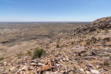 view of a desert valley from a rocky mountain