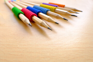 Obraz premium school background, colored pencils lie on a light table, close-up, the concept of student writing supplies, back to school