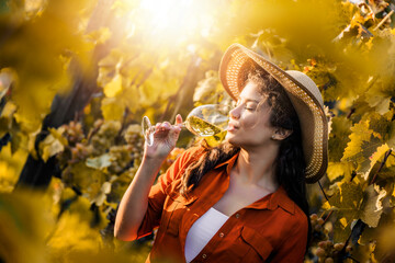 Woman tasting wine in the vineyard - 526388625
