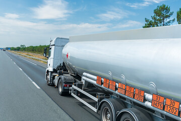 Fuel tanker truck circulating on the highway with orange panels identifying the danger and merchandise transported, transport under ADR regulations.