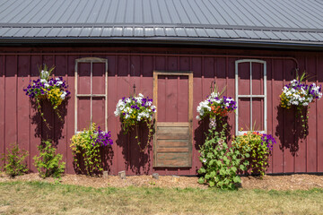 Fototapeta na wymiar Flowers, window and door frames on the exterior of a garden shed