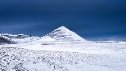 Fototapeta na wymiar A panoramic view of the plain and mountains in Iceland. Wild landscape and dark skies before the storm. A view of Iceland's nature in winter time.