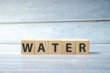 word water on wooden blocks and blue background