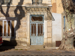 A typical derelict facade with closed shutters in the Southern France village of Tournissan