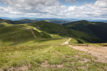 Fototapeta na wymiar mountain roads along green peaks in rural Carpathians