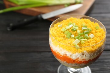 Traditional russian salad Mimosa served on dark wooden table. Space for text