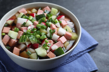 Delicious cold okroshka with kvass on black table, closeup. Traditional Russian summer soup