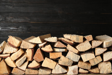 Fototapeta premium Cut firewood on black background. Heating in winter