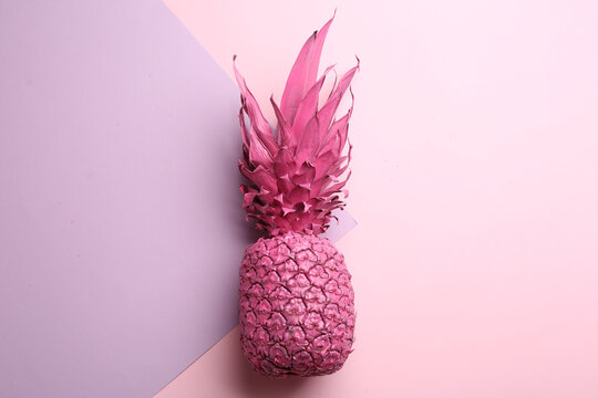 Pink pineapple on color background, top view. Creative concept
