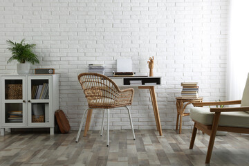 Comfortable writer's workplace interior with typewriter on desk near white brick wall