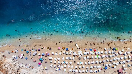 Fototapeta na wymiar Aerial view of a crowded beach, umbrellas and people on the sand stock photo - Antalya, Kaş