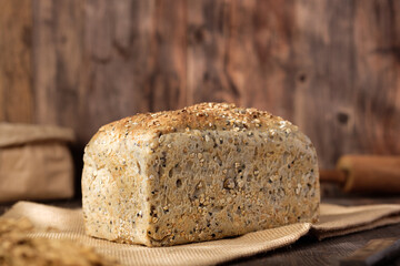 whole wheat baking bread with grains for healthy eating on wood table in kitchen