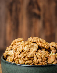 walnut in ceramic bowl on kitchen wooden table