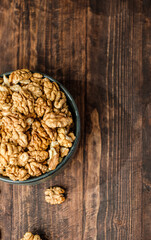 top view walnut in ceramic bowl on kitchen wooden table