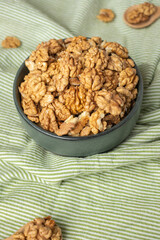 wallnut in ceramic bowl on green tablecloth in kitchen