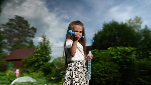 Little girl plays with soap bubbles outdoors. Video 360 degrees.