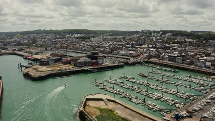 A port with many moored yachts in a touristic European city on the banks of the English Channel. Aerial view, Etretat, France.