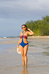 Woman body pretty stand enjoy with swimsuit and hat at beach