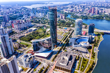 Aerial view of central part of modern city with skyscrapers and residential buildings. River and bridge on summer day. Yekaterinburg. Russia