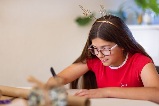 girl wrapping present at Christmas time with antler headband
