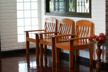Three wooden chairs were arranged in a row by the window.