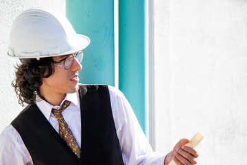 Elegant young engineer - architect working with his blueprints in hand while supervising a construction site in Venezuela
