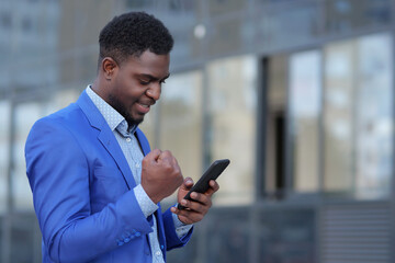 African American man happy winning tender for business after upgrading startup. Mature businessman...