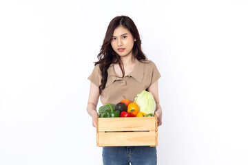 Cheerful smiling Asian woman holding a wooden box of vegetables after shopping isolated on a white background