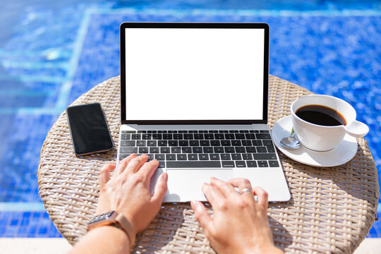 Woman by the pool working on laptop computer