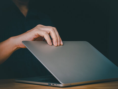 Man open or close laptop cover lid on wooden table by hand. Starting working or job done using laptop for working. Working concept.