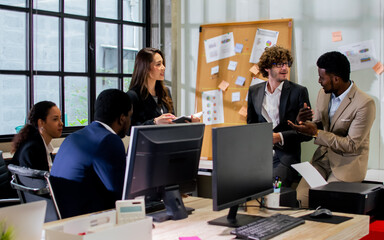 Diverse and multiracial smart businesspeople wearing formal suits, using computer, discussing, meeting, brainstorming together about company marketing plan or creative idea in indoor modern office.