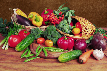  A variety of colorful fresh vegetables and flowers on a wooden table. 