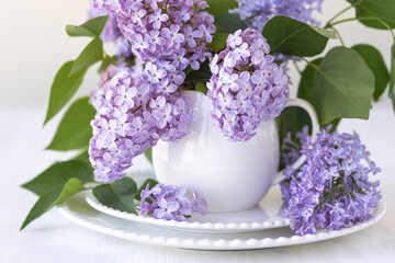 Beautiful spring composition with lilac flowers in a white cup for countryside decor