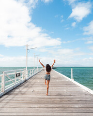 woman jumping on the Magnetic Island jetty.