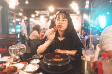 Portrait happy smile young adult asian woman holding fried chicken at Korean restaurant.