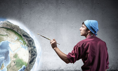 Young artist drawing earth globe