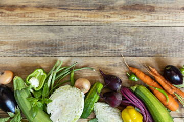 Organic vegetables for healthy cooking background. Fall harvest. The concept of vegan or diet food. Various vegetables on a rustic kitchen table. View from above. Copy space.
