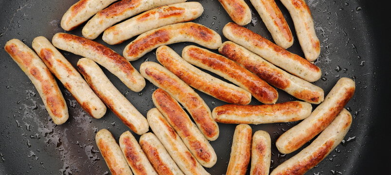 lots of delicious fried sausages in the pan 