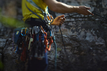 Climber works with a rope during the ascent,  face is not visible, close-up.