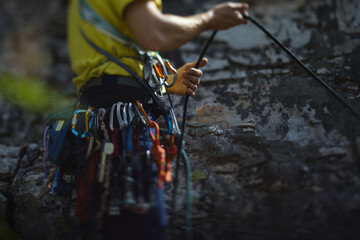 Climber works with a rope during the ascent,  face is not visible, close-up.
