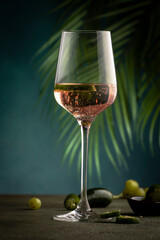 Rose pink wine with jalapeno pepper in wine glass, dark background, copy space