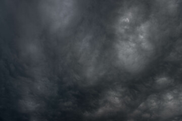 Obraz na płótnie Canvas Czarne, ciężkie, pofałdowane burzowe chmury. Budzą one grozę zapowiadając nadejście gwałtownych opadów i wiatru stanowiącego zagrożenie dla życia.
