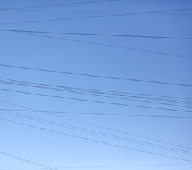Electric wires against the blue sky. Background