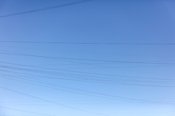 Electric wires against the blue sky. Background