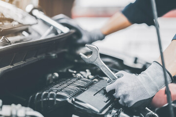 Mechanic works on the engine of the car in the garage. Repair se